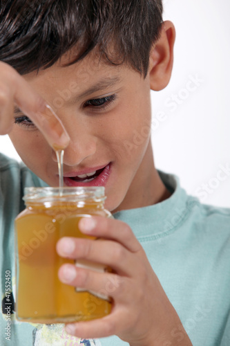 Photo: Little boy holding jar of honey Little boy holding jar of honey