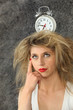 Foto: young woman with a clock on her head young woman with a clock on her head
