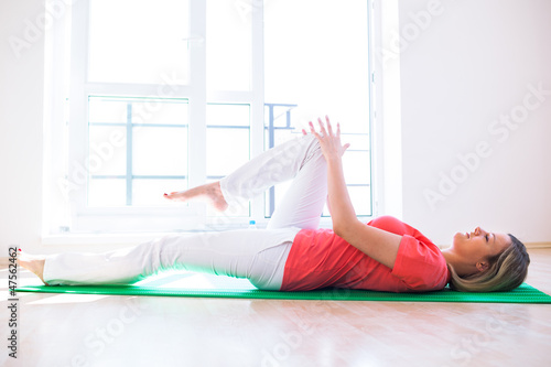 Photo: Pretty young woman doing YOGA exercise at home Pretty young woman doing YOGA exercise at home