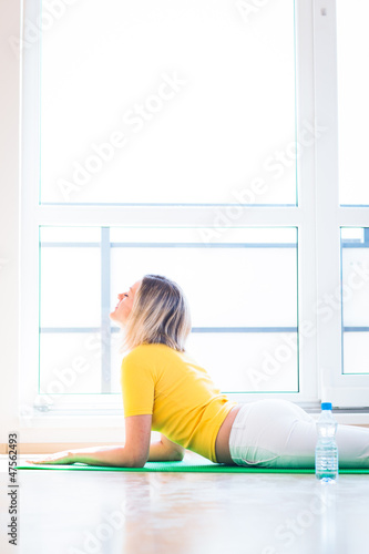 Photo: Pretty young woman doing YOGA exercise at home Pretty young woman doing YOGA exercise at home