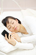 スマートフォンを持ったまま寝る女性