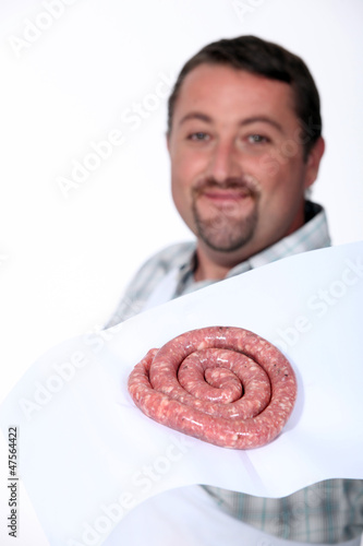 Photo: A butcher proudly presenting his sausages. A butcher proudly presenting his sausages.