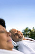 Husband and wife relaxing on sun loungers