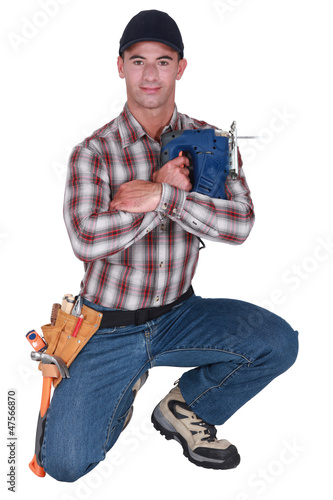Photo: A handyman with a jigsaw. A handyman with a jigsaw.