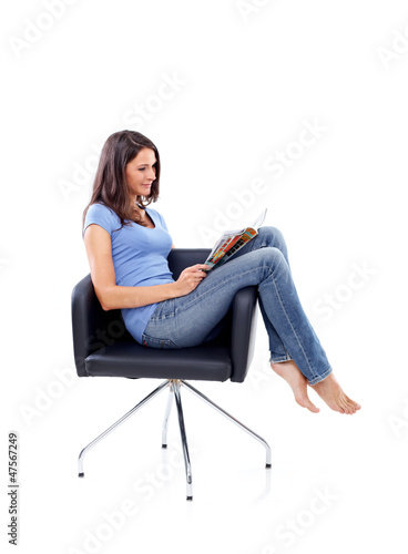 Photo: Casual 20s women sitting with magazine Casual 20s women sitting with magazine