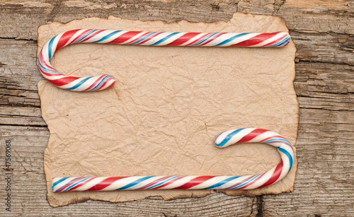 Photo: Colorful Candy cane on an old retro paper background Colorful Candy cane on an old retro paper background