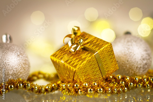 Photo: Christmas gift and baubles over shiny lights background Christmas gift and baubles over shiny lights background