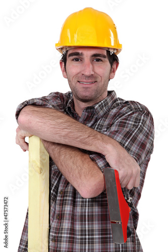 Photo: Tradesman holding a wooden plank and a plane Tradesman holding a wooden plank and a plane