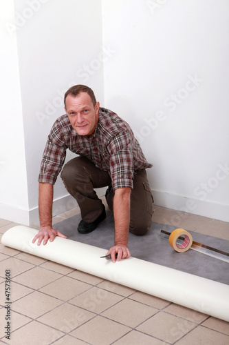 Photo: Man laying pvc flooring Man laying pvc flooring