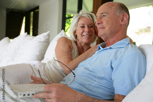 Photo: Couple sat on their veranda with laptop Couple sat on their veranda with laptop