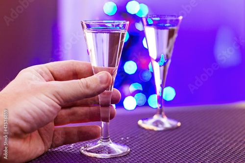 Photo: Hand taking glass of vodka at christmas time Hand taking glass of vodka at christmas time