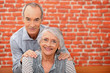 Older couple in front of a brick wall