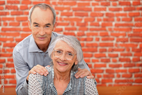 Photo: Older couple in front of a brick wall Older couple in front of a brick wall
