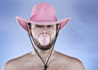 Photo: Cowboy in pink hat blowing a gumball. Cowboy in pink hat blowing a gumball.