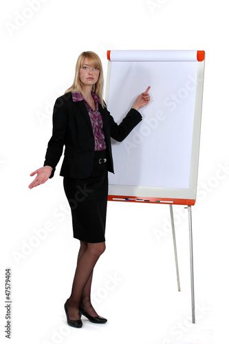 Photo: Businesswoman standing by a flip chart Businesswoman standing by a flip chart