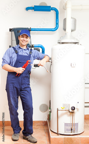 Photo: Technician repairing an hot-water heater Technician repairing an hot-water heater