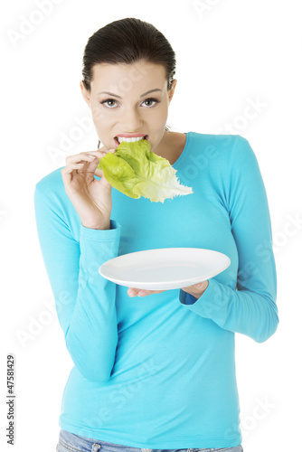 Photo: Fit young beautiful woman eating salat Fit young beautiful woman eating salat