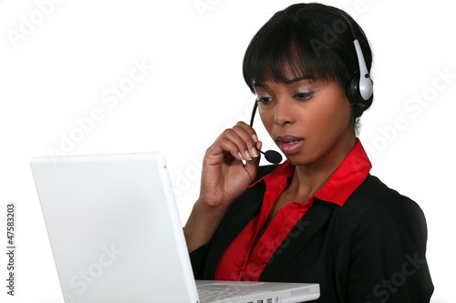 Photo: Businesswoman wearing a headset with a laptop Businesswoman wearing a headset with a laptop