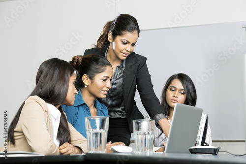 Photo: Indian colleagues working around a laptop Indian colleagues working around a laptop