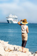 Foto: Woman with hat standing at sea Woman with hat standing at sea