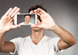 Mann fotografiert sich selbst mit seinem Mobiltelefon
