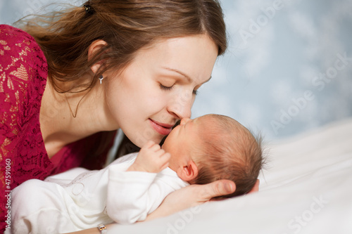 Photo: picture of happy mother with baby in bedroom picture of happy mother with baby in bedroom