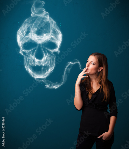 Photo: Young woman smoking dangerous cigarette with toxic skull smoke Young woman smoking dangerous cigarette with toxic skull smoke