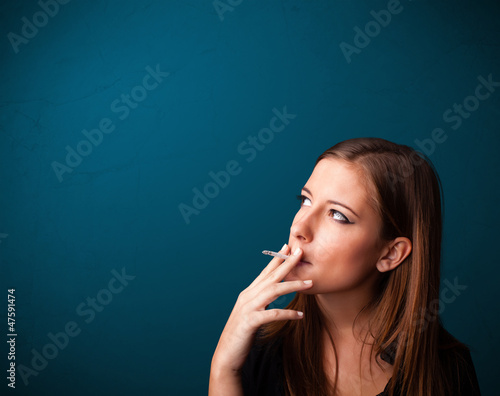 Photo: Beautiful woman smoking cigarette vith copy space Beautiful woman smoking cigarette vith copy space