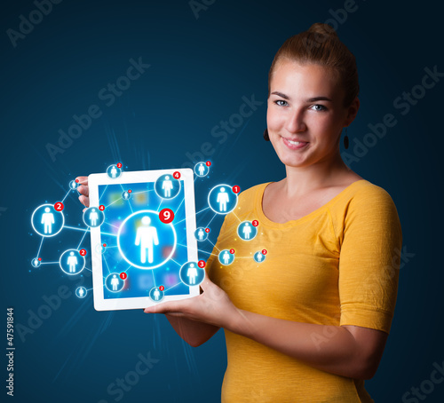 Photo: young woman holding tablet with social network icons young woman holding tablet with social network icons