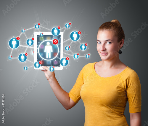 Photo: young woman holding tablet with social network icons young woman holding tablet with social network icons