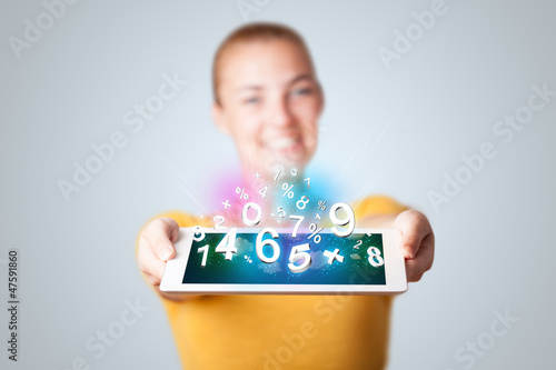 Photo: Young woman holding tablet with numbers Young woman holding tablet with numbers
