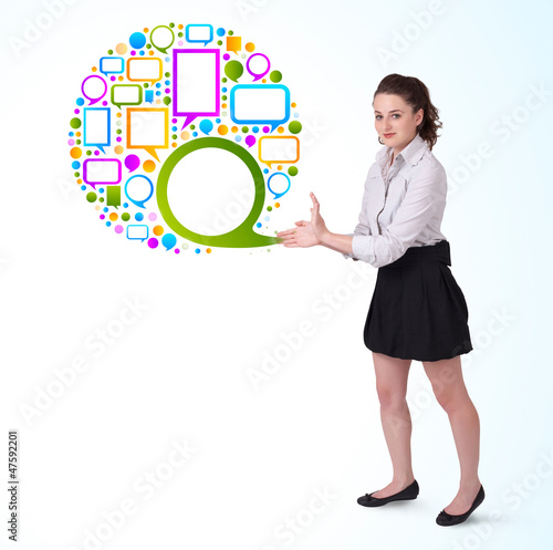 Photo: Young business woman presenting colourful speach bubble Young business woman presenting colourful speach bubble
