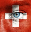 Photo: Human face painted with flag of Switzerland Human face painted with flag of Switzerland