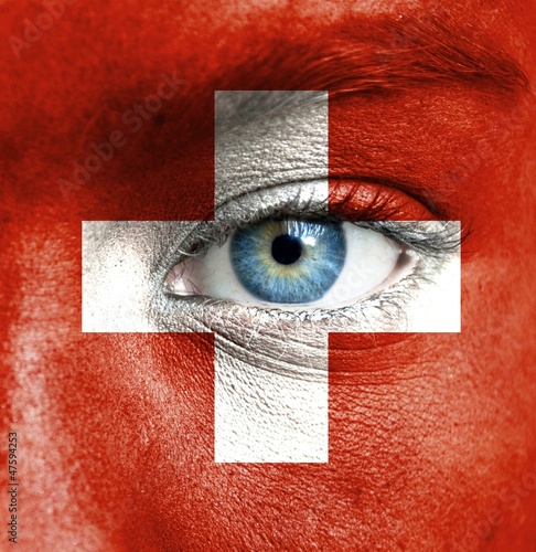 Photo: Human face painted with flag of Switzerland Human face painted with flag of Switzerland