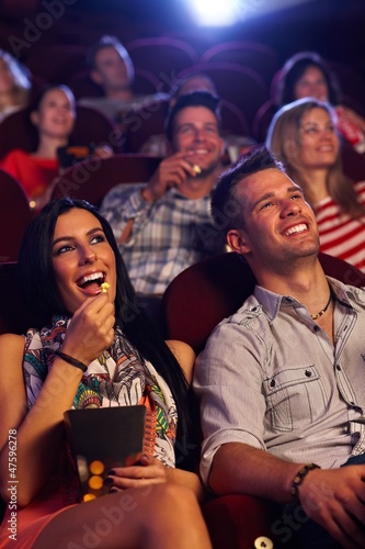 Photo: Young couple sitting in cinema smiling Young couple sitting in cinema smiling