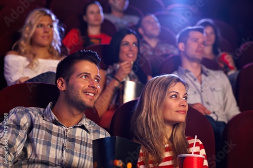 Photo: Young people sitting at movie theater Young people sitting at movie theater