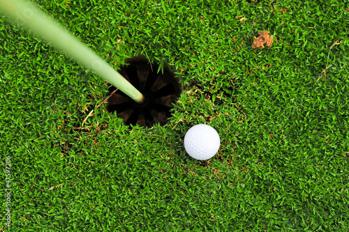 Photo: golf ball on lip of cup golf ball on lip of cup