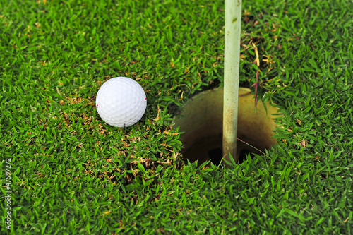 Photo: golf ball on lip of cup golf ball on lip of cup