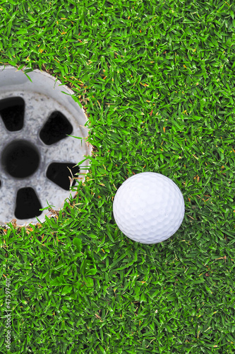 Photo: golf ball on lip of cup golf ball on lip of cup