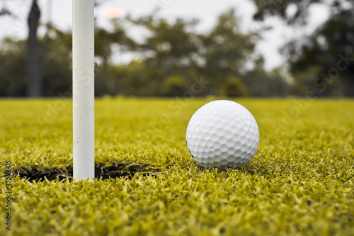 Photo: golf ball on lip of cup golf ball on lip of cup