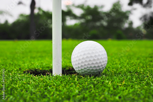 Photo: golf ball on lip of cup golf ball on lip of cup