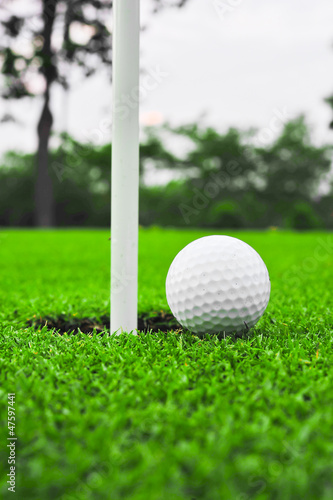 Photo: golf ball on lip of cup golf ball on lip of cup