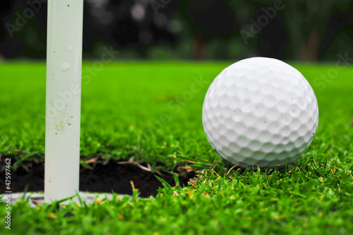 Photo: golf ball on lip of cup golf ball on lip of cup