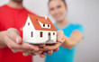 Young couple holding miniatre house