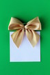 Foto: white blank with a gold bow on a green background white blank with a gold bow on a green background