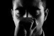 Man with fist and eyes closed