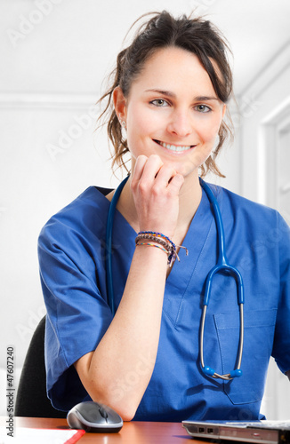 Photo: Nurse sitting at desk at work Nurse sitting at desk at work