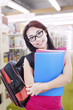 Beautiful woman with bag and folder in library