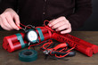 Human makes timebomb on wooden table on black background