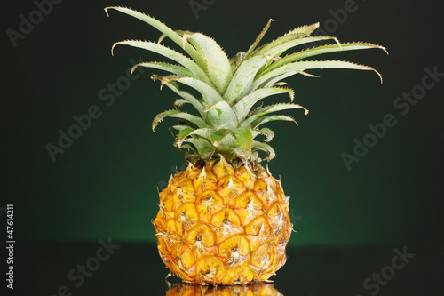 Photo: Ripe pineapple on dark green background Ripe pineapple on dark green background